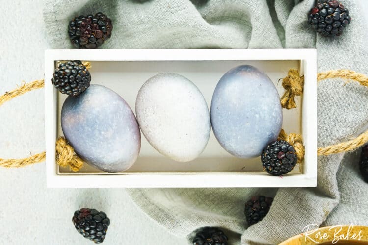 dyed eggs displayed in a wooden crate on table for decoration 