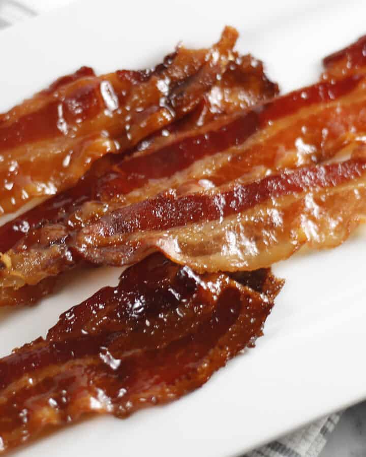 Candied Bacon slices on a white platter