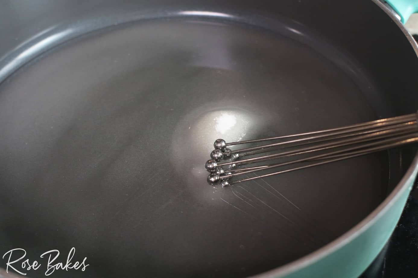 water in skillet with sugar and whisk