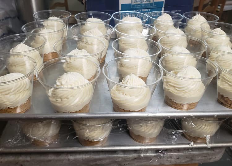 The creamiest No-Bake Cheesecake Cups stacked on cookie sheets