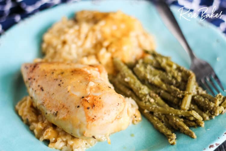The Best Cheesy Chicken & Rice Casserole on a plate with asparagas