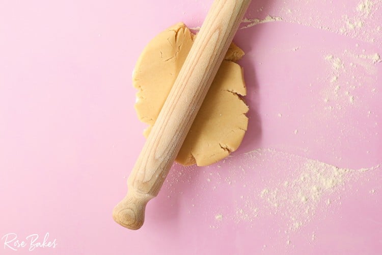 Cookie dough being rolled out on a floured surface