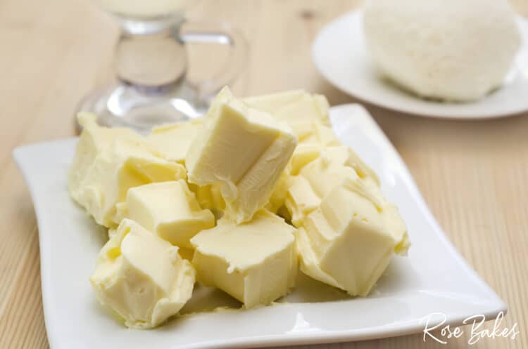 Cubed butter on a white plate coming to room temperature.