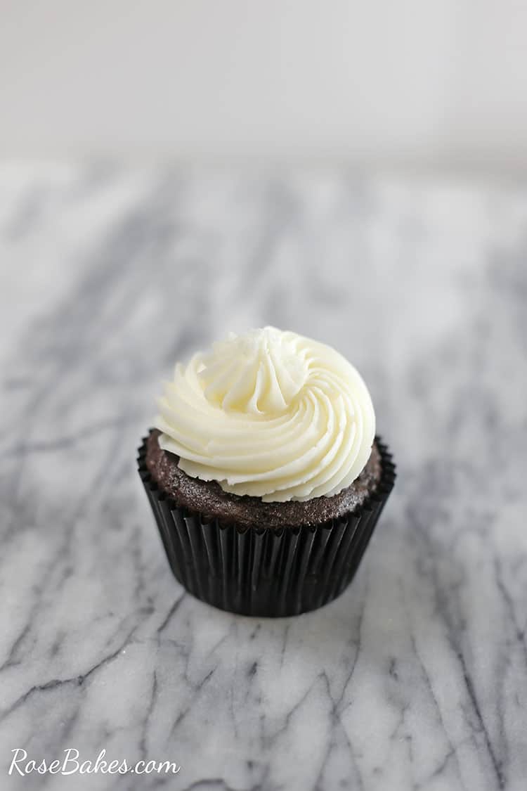 chocolate cupcake with vanilla frosting in a liner on a counter