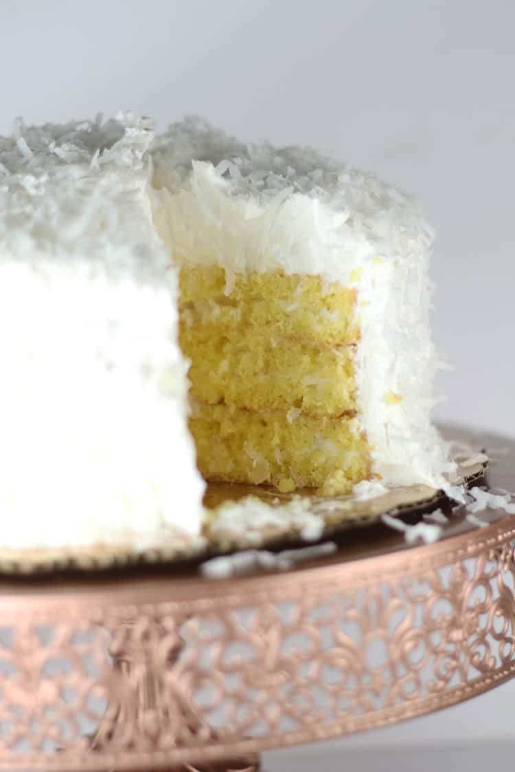 coconut cake with slice missing on rose gold cake stand