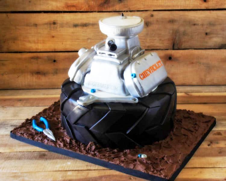Tire and Engine Cake sitting on cake board made to look like mud