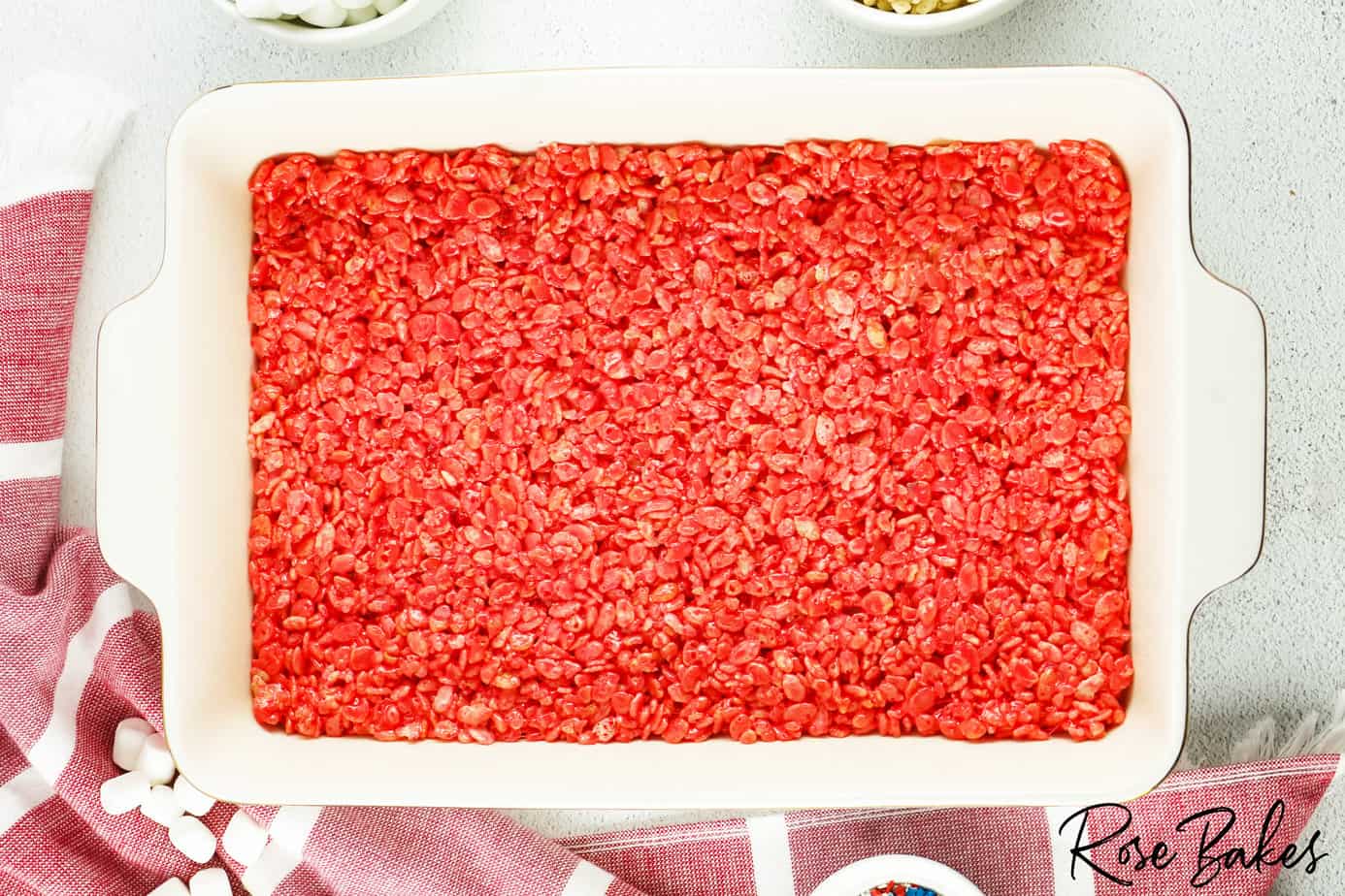 red rice krispies pressed flat in a white baking dish 