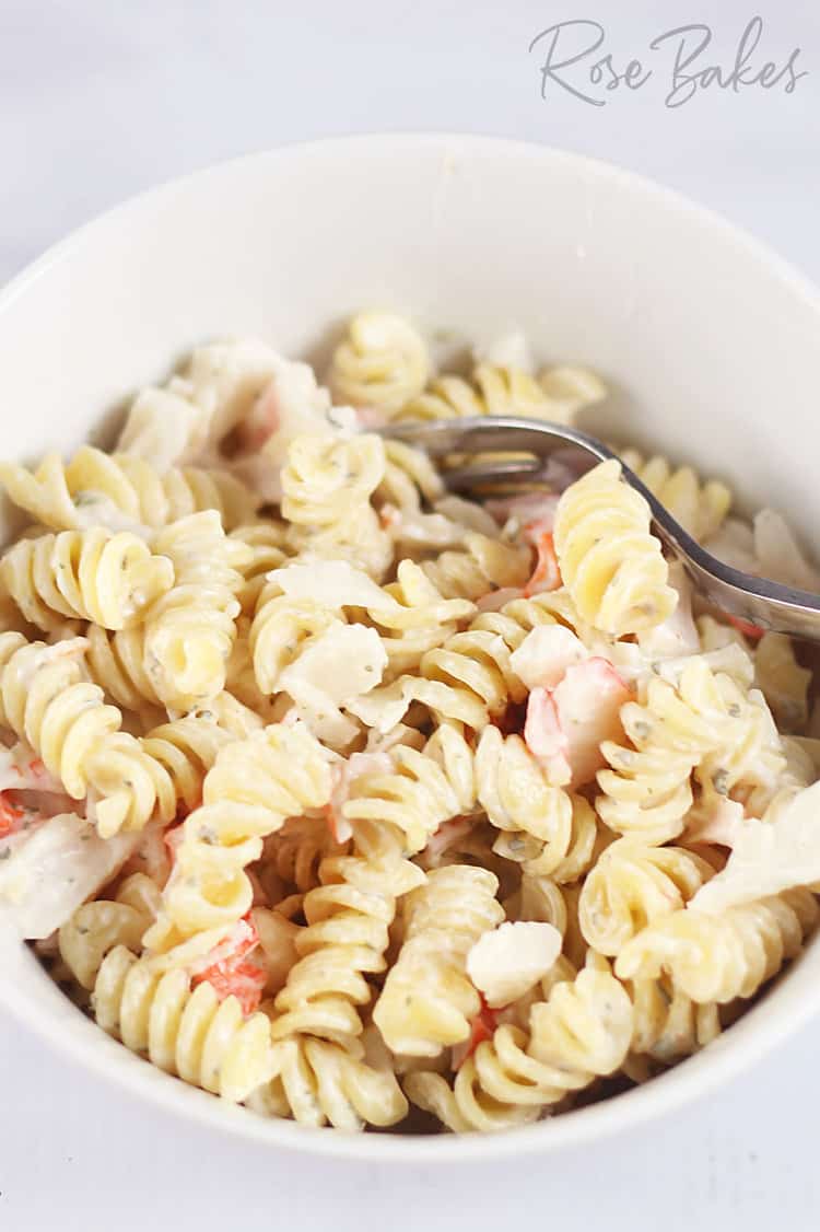Creamy Crab Pasta Salad in a white bowl with a fork
