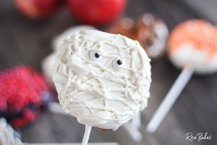 apple slice dipped in white chocolate with googly eyes added 