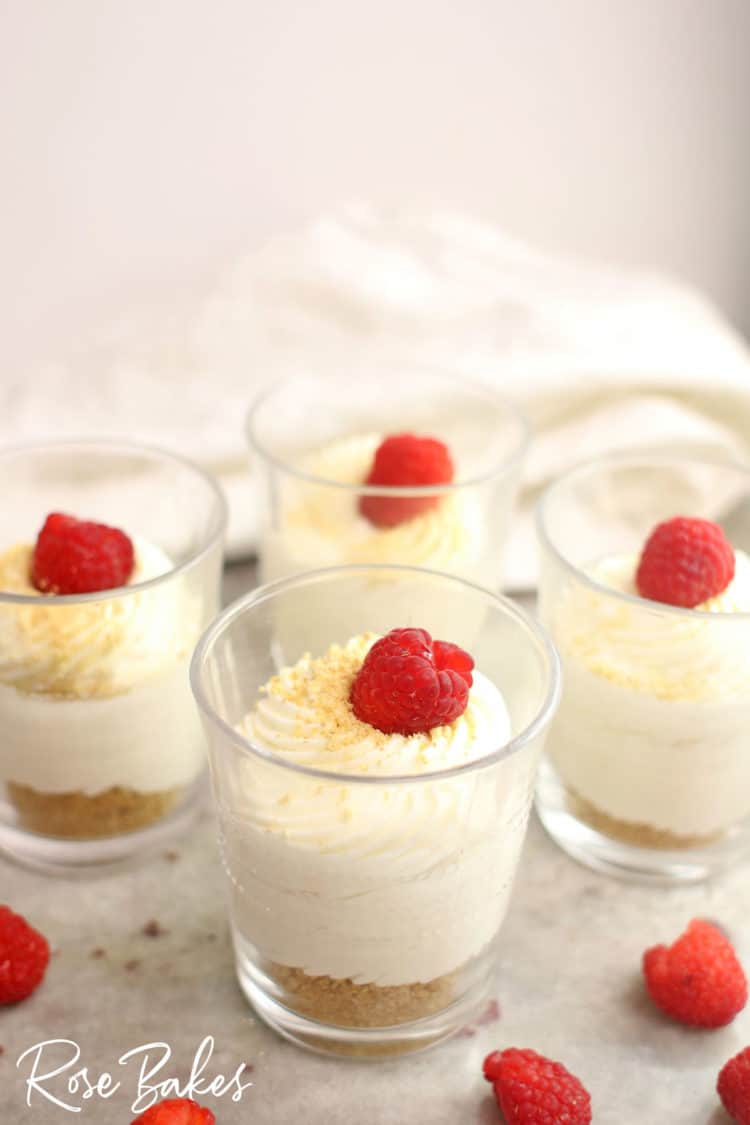 Creamy No-Bake Cheesecake Cups Recipe in cups with raspberries on top 