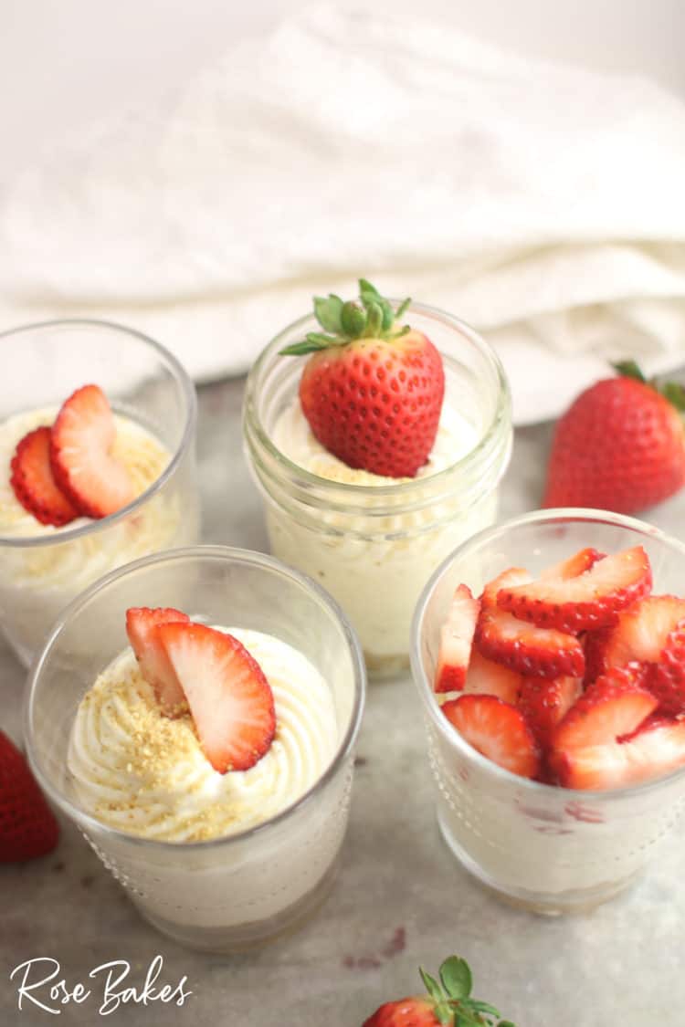 The creamiest No-Bake Cheesecake Cups Recipe in cups with strawberries on top 