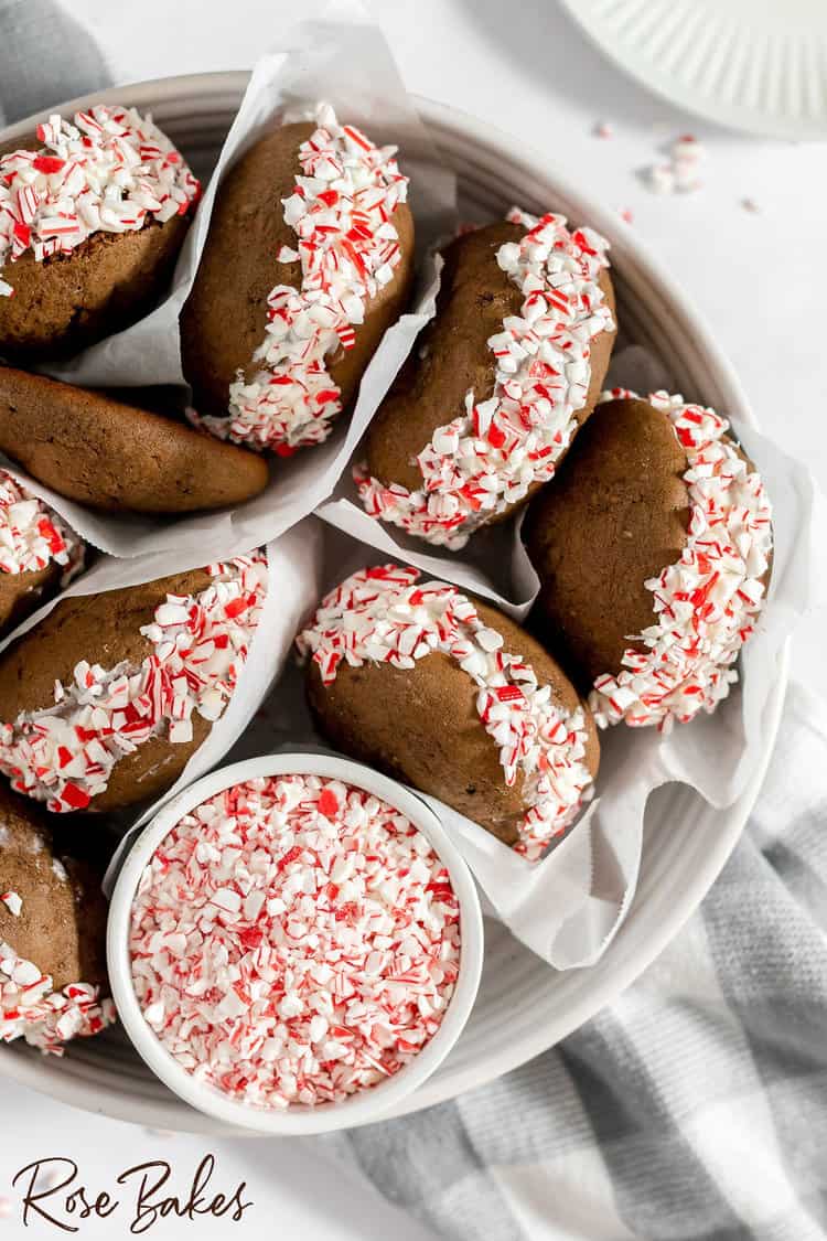 Chocolate Peppermint Whoopie Pies in a white serving dish with a ramekin of crushed peppermints.