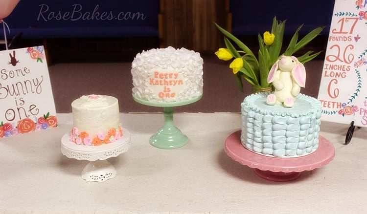 Three Somebunny is One cakes on cake stands.