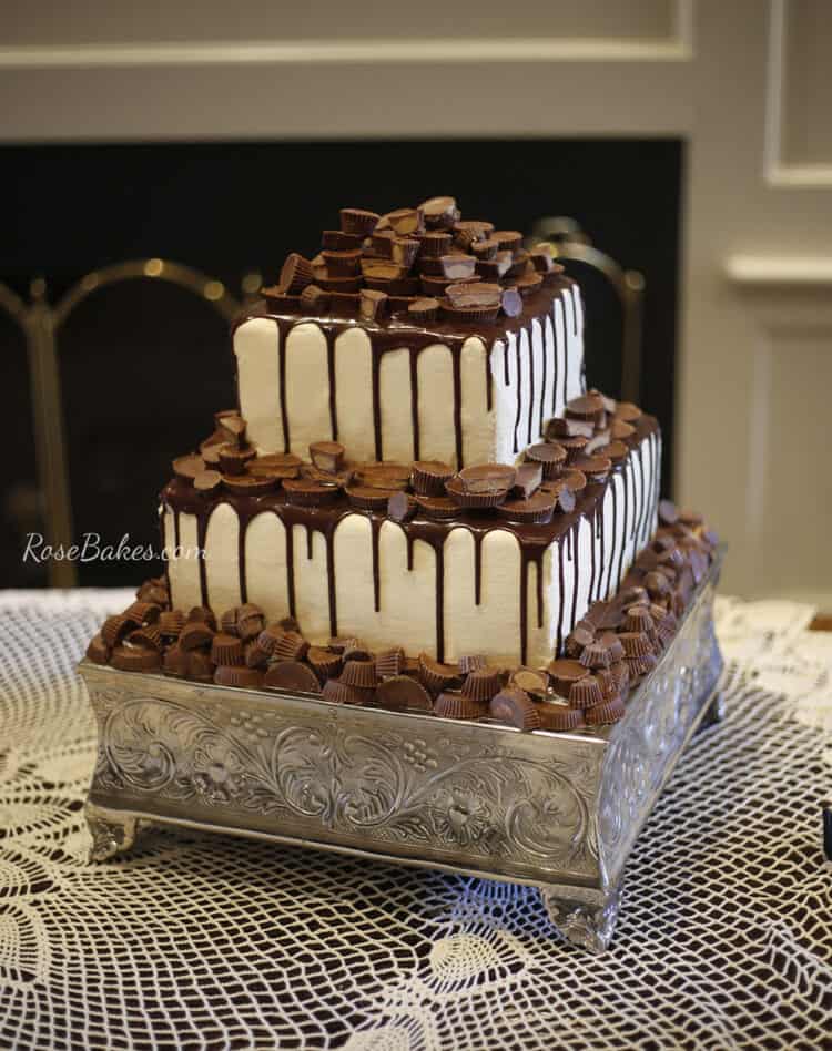 2 tier grooms cake white with chocolate drizzle and reeses peanut butter cups as topper and decor