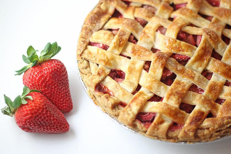 Strawberry Rhubarb Pie whole with fresh strawberries