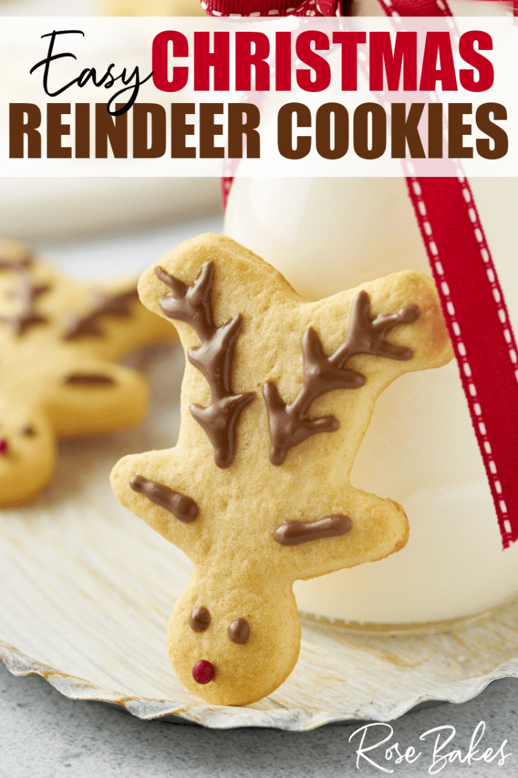 A simply decorated Christmas reindeer cookie propped up against a glass of milk, with the text, "Easy Christmas Reindeer Cookies"